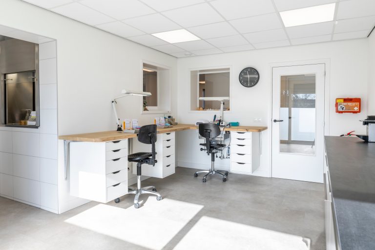Moderne tandprothetische praktijk met witte behandelstoel, instrumentenkast en professionele apparatuur