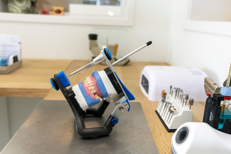 Kunstgebit in een articulator op de werkbank van het tandtechnisch laboratorium