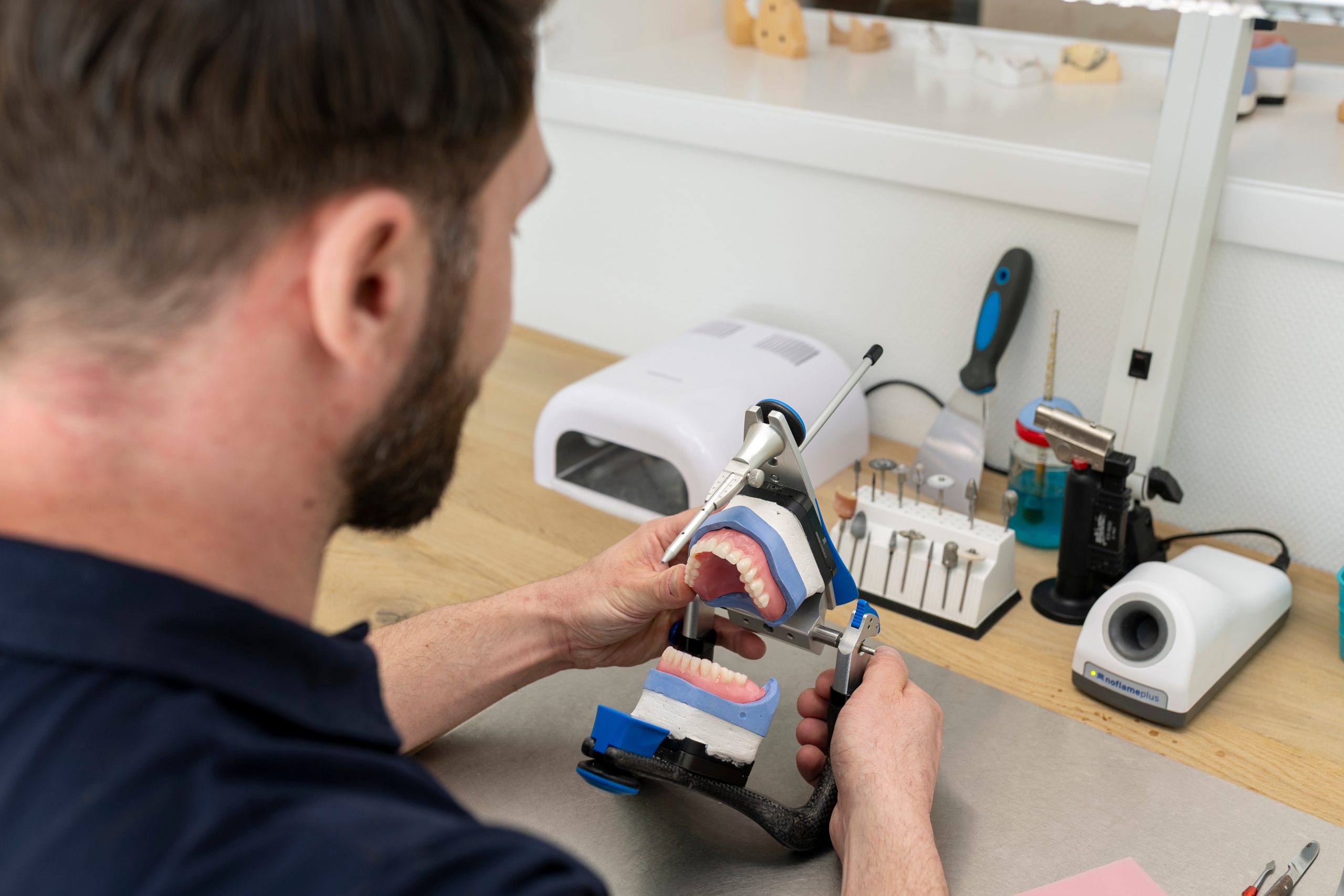 Elektricien werkt aan elektrische installatie en bekabeling in witte meterkast met gereedschap